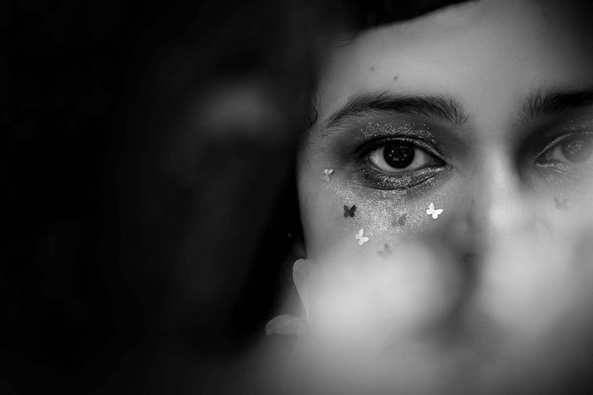 Fotografía close-up en blanco y negro enfocada en los ojos de una joven.